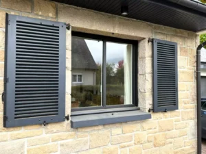 Fenêtre à frappe aluminium noire avec volets assortis installée à Pacé par Artimob Menuiserie, expert local en menuiserie.