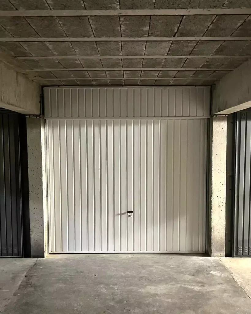 Porte de garage basculante installée dans un appartement à Rennes, augmenté la largeur de passage d'environ 15 cm