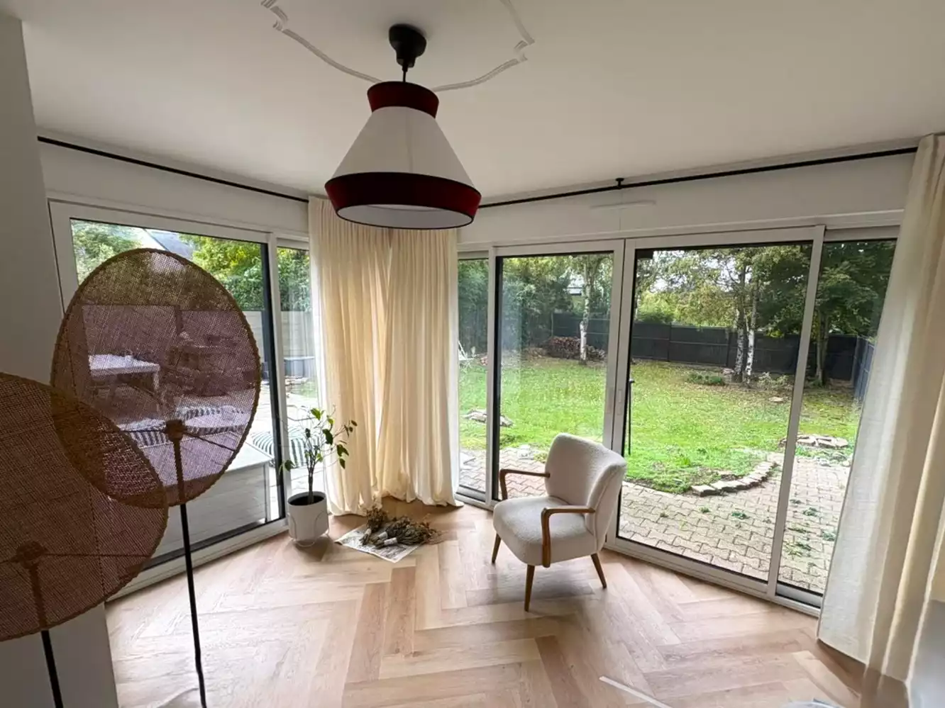 Baie vitrée coulissante aluminium blanche intérieures ouvrant sur jardin à Pacé, réalisée par Artimob Menuiserie