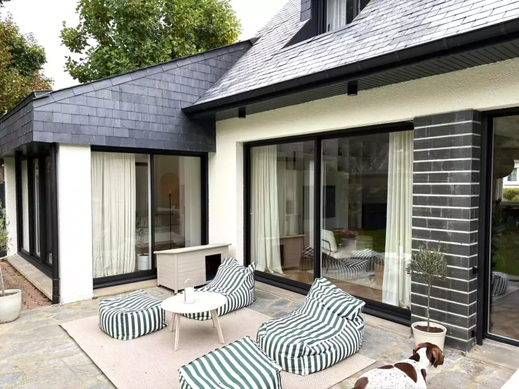 Baies coulissantes aluminium noires ouvrant sur terrasse à Pacé, réalisées par Artimob Menuiserie, expert en menuiserie extérieure.