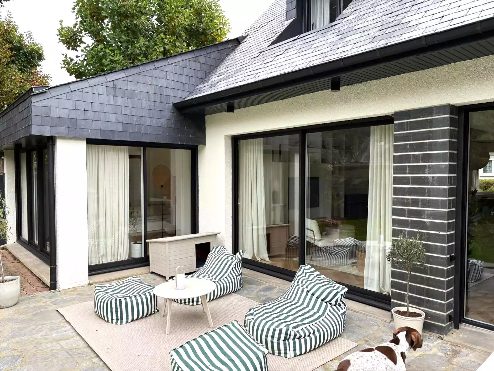 Baies coulissantes aluminium noires ouvrant sur terrasse à Pacé, réalisées par Artimob Menuiserie, expert en menuiserie extérieure.