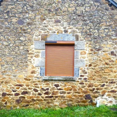 Volets roullantes solaires Artimob Volet roulant solaire, couleur marron, installé dans l'ancienne maison à Combourg par Artimob Menuiserie, entreprise artisanale en 35