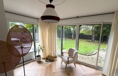 Baie vitrée coulissante aluminium blanche intérieures ouvrant sur jardin à Pacé, réalisée par Artimob Menuiserie