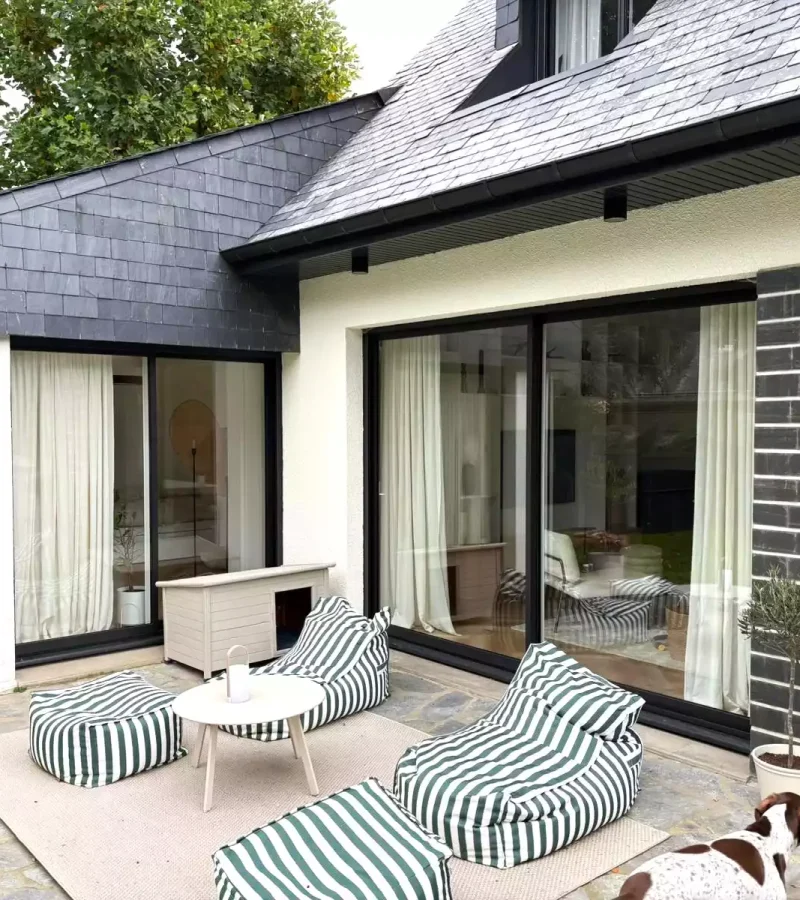 Baies coulissantes aluminium noires ouvrant sur terrasse à Pacé, réalisées par Artimob Menuiserie, expert en menuiserie extérieure.