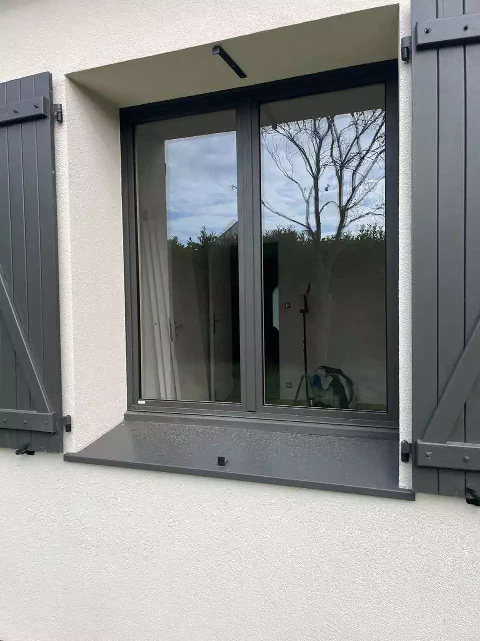 Fenêtre mixte bois-alu MéO anthracite posée en rénovation, avec volets battants, par Artimob Menuiserie Rennes.