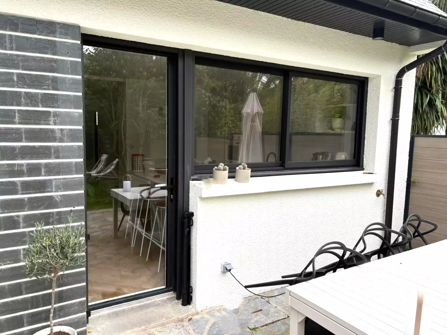 Porte-fenêtre coulissante aluminium noire installée à Pacé par Artimob Menuiserie, expert en menuiserie sur mesure.