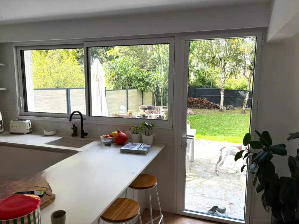 Porte-fenêtre coulissante aluminium avec volet roulant intégré en caisson caché, installée à Pacé par Artimob Menuiserie.