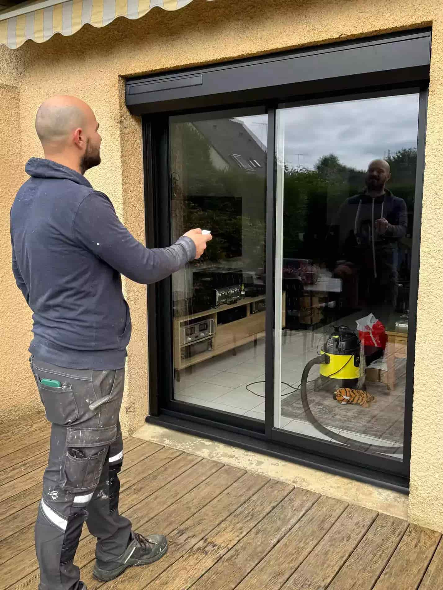 artisan local installe une fenêtres avec volet roulant